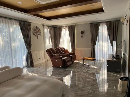 a living room with a couch and a chair at Toscana Valley, Khao Yai - Private pool- 12 people in Ban Rai Khlong Sai