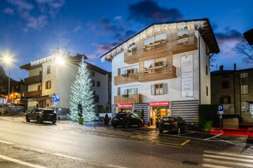 a building with a christmas tree next to a street at Hotel Diffuso Locanda Elisa in Dimaro