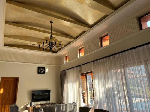 a living room with a coffered ceiling and windows at Toscana Valley, Khao Yai - Private pool- 12 people in Ban Rai Khlong Sai