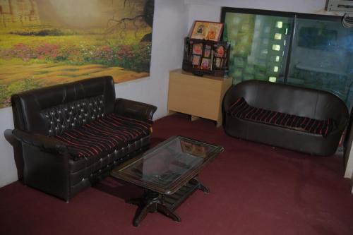 a living room with two leather chairs and a coffee table at Hotel Quality Time in Udaipur