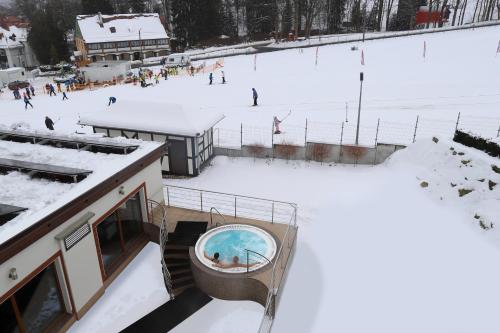a ski resort with a pool in the snow at Hotel Buczyński Medical & SPA in Świeradów-Zdrój