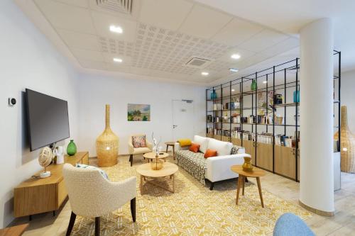 un salon avec un canapé, des chaises et une télévision dans l'établissement Résidence Le Mans, au Mans