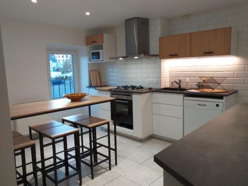 une cuisine avec des appareils électroménagers blancs et des armoires en bois dans l'établissement Charmy, à Granville