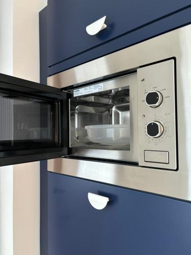 La cuisine est équipée d'un four micro-ondes et de placards bleus. dans l'établissement Orange & Art, à Clermont-Ferrand