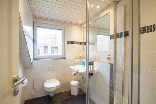 a bathroom with a toilet and a sink and a shower at Haus Halligenblick Amrum in Wittdün