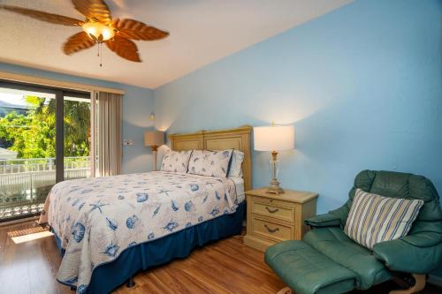 a bedroom with a bed and a chair and a window at Nautical Adventures in Paradise in Key West