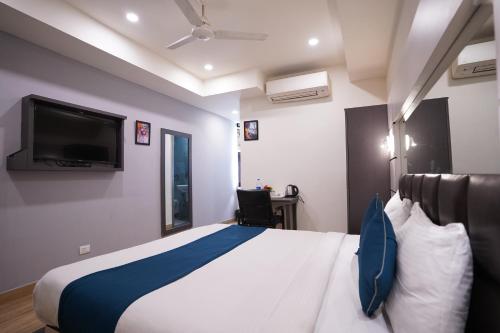 1 dormitorio con 1 cama grande y TV en Hotel Lyf Corporate Suites - Kirti Nagar en Nueva Delhi