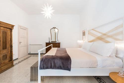 Schlafzimmer mit einem großen weißen Bett mit einem Kopfteil aus Holz in der Unterkunft Modern Comfort, Poetic Charm in Rom