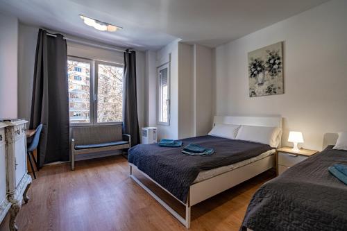 a bedroom with two beds and a window at Rooms Jardín Botánico in Valencia