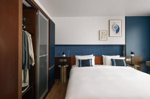 a bedroom with a large bed with blue walls at Crowne Plaza Madrid - Centre Retiro, an IHG Hotel in Madrid