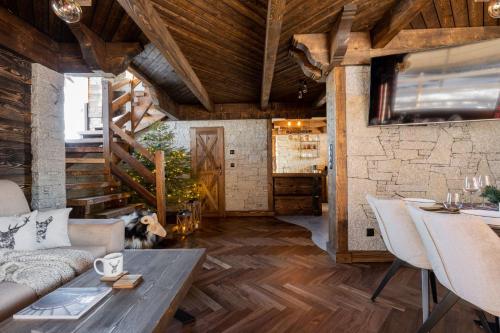 - un salon avec des plafonds en bois, une table et des chaises dans l'établissement Osada Góralska Ostoja Pod Gubałówką z Jacuzzi, à Zakopane
