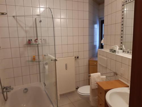 a bathroom with a tub and a toilet and a sink at NEU! Moderne Ferienwohnung Zwickau in Zwickau