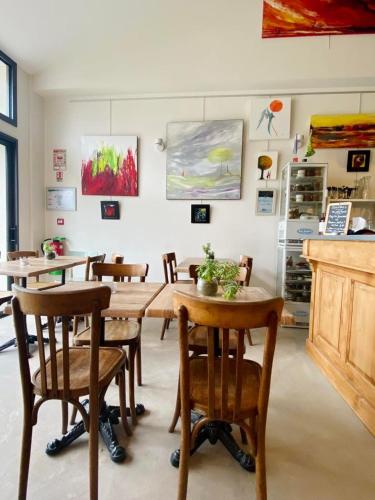 une chambre avec des tables, des chaises et des peintures murales dans l'établissement La LocaLuna, à Civray-de-Touraine