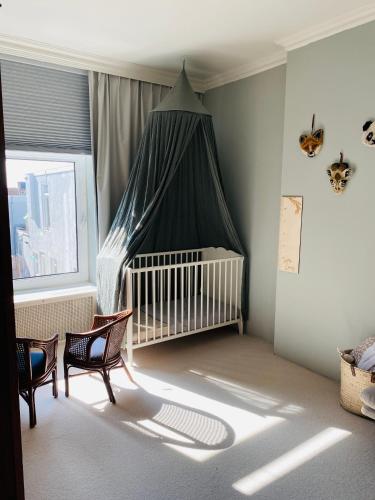 een babybedje met een baldakijn in een kamer bij Familiehuis aan zee met ruim dakterras in Zandvoort