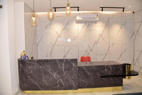 een badkamer met een zwart marmeren aanrecht en verlichting bij Hotel Sai Krishna in Shirdi