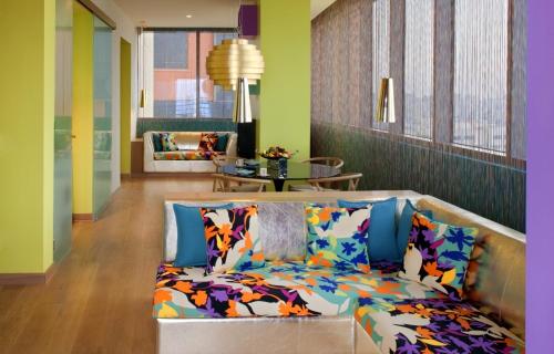 a living room with a couch with colorful pillows at Symphony Style Hotel Kuwait in Kuwait