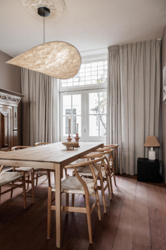 een eetkamer met een grote houten tafel en stoelen bij Familiehuis aan zee met ruim dakterras in Zandvoort