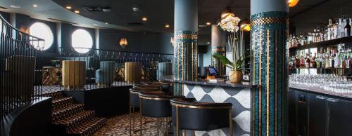 un bar avec une rangée de tabourets et un comptoir avec des boissons dans l'établissement Des vacances au coeur de Dinard - Appartement entier, à Dinard