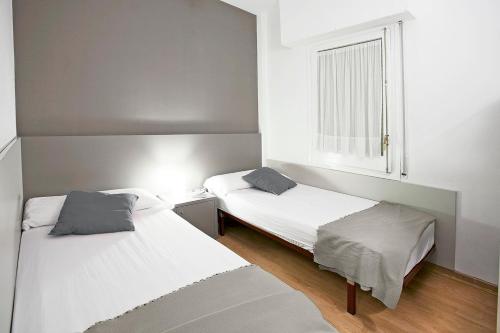 1 dormitorio con 2 camas y ventana en Sant Jordi Apartments Sagrada Familia en Barcelona