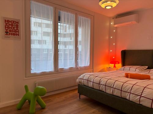 a bedroom with a bed and a green toy in front of a window at Orange & Art in Clermont-Ferrand