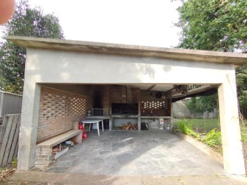 un pabellón con una mesa y un banco en un patio en Buena energía y confort, en La Floresta