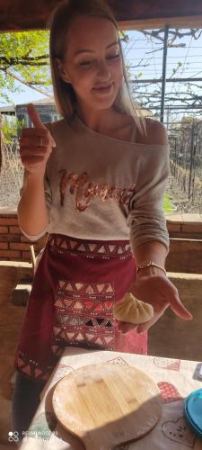 a young woman is pointing at a plate of food at Lunisi Kvareli in Kvareli