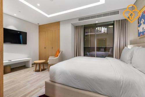 a bedroom with a bed and a desk and a tv at Keysplease Modern Studio Near Beach, Murjan JBR 617 in Dubai