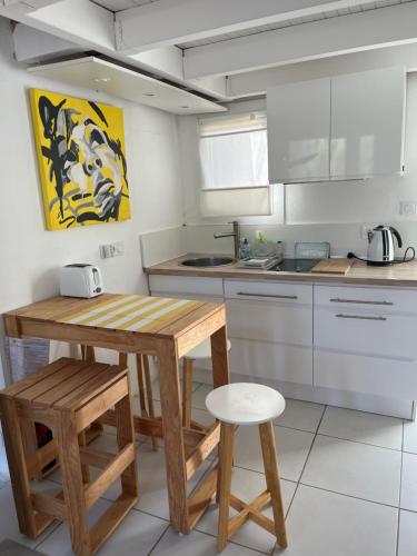 - une cuisine avec une table en bois et un tabouret dans l'établissement Helles freundliche Ferienhaus für Naturisten FKK auf Korsika, à Linguizzetta