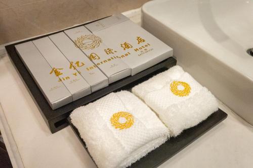 duas toalhas numa caixa ao lado de um lavatório em Horgos Golden International Hotel em Kurgash