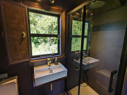 a bathroom with two sinks and a window at Blue Sky Huts in Chediston