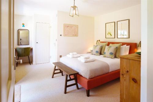 a bedroom with a large bed and a table at Gatehouse North in Worstead