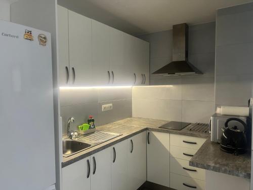a kitchen with white cabinets and a sink at Relax apartamento 5 in Las Palmas de Gran Canaria