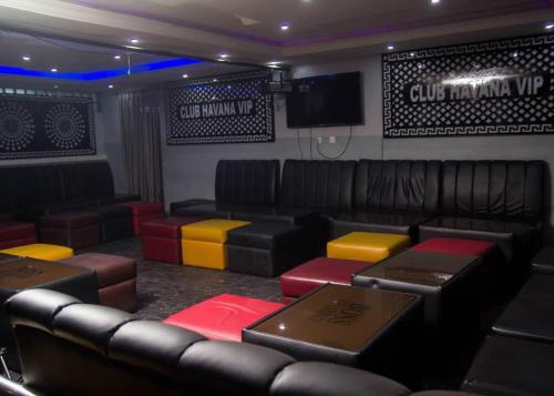 a room with chairs and a couch and a tv at BOSS HOTELS & SUITES in Lagos