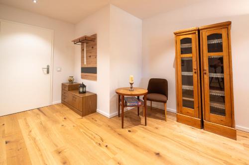 a room with a table and a chair and a cabinet at Ferienwohnungen - barrierefrei - im sanierten Gutshof in Lalendorf