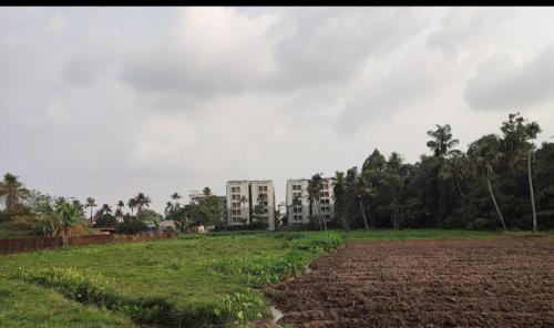 un campo con un gran edificio en el fondo en APPLE APPARTMENT, en Kāladi