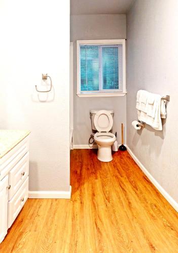 a bathroom with a toilet and a window at 1BR Nest in Grass Valley, CA in Grass Valley