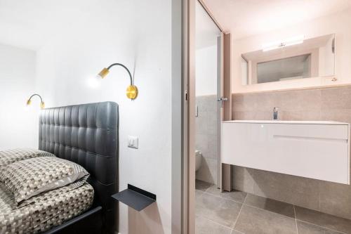 een slaapkamer met een bed, een wastafel en een spiegel bij Appartamento al centro di Cagliari (Marina) in Cagliari