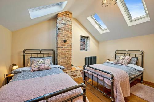 two beds in a room with skylights at Finest Retreats - The Old Smithy in Belchford