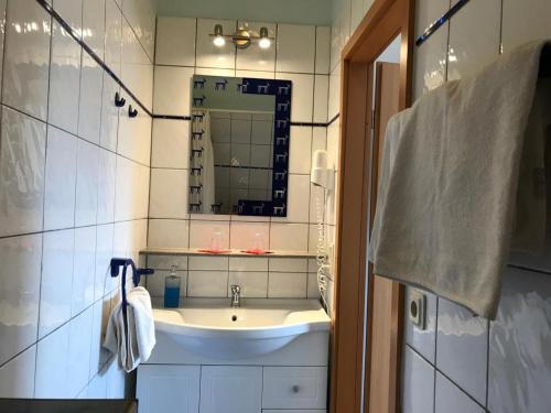 ein Bad mit einem Waschbecken und einem Spiegel in der Unterkunft Fewo by Seeblick Ferien Edersee, Am See, Haustiere auf Anfrage in Waldeck