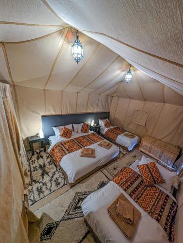 a room with two beds in a tent at Camel Luxury Camp in Merzouga