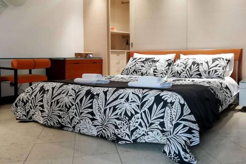 - une chambre avec un lit et une couverture noire et blanche dans l'établissement Mauro apartment. Fresh and peaceful., à Moltrasio