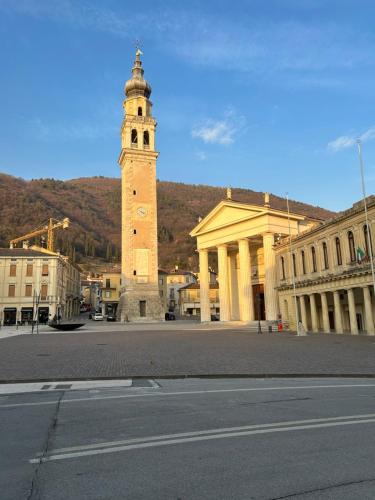 een klokkentoren in het midden van een stad bij AMIA rooms & wine in Valdobbiadene