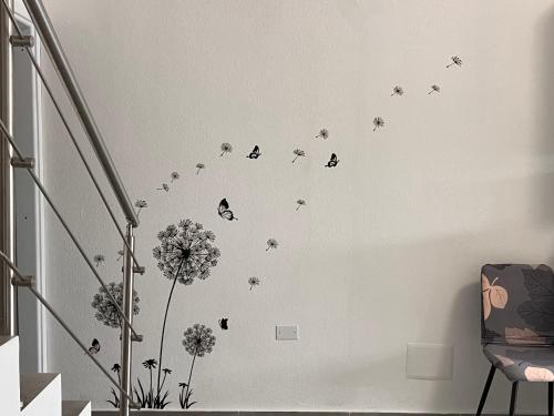 un mur avec des papillons et des fleurs dans une pièce dans l'établissement Urban charme loft, à Dorgali