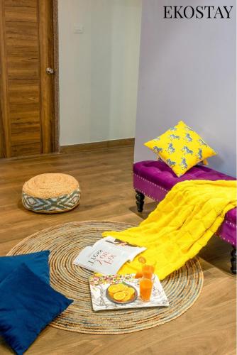 a yellow blanket on the floor next to a chair at EKOSTAY - Bliss Apartment in Candolim