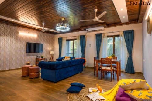 a living room with a blue couch and a table at EKOSTAY - Bliss Apartment in Candolim