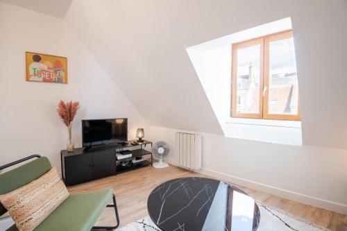 Il comprend un salon blanc doté d'une télévision et d'une fenêtre. dans l'établissement Les mansardes Amboisiennes, à Amboise