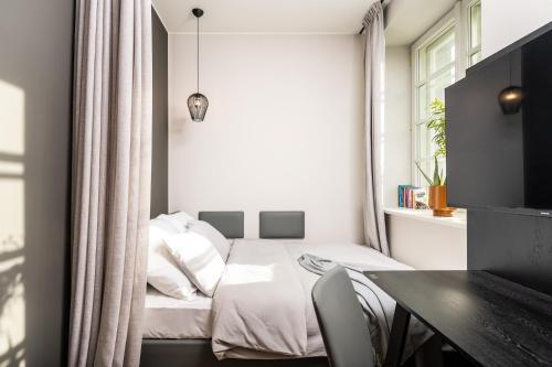 a small bedroom with a bed and a table at MILESTONE Krakow Center Urban Living in Krakow