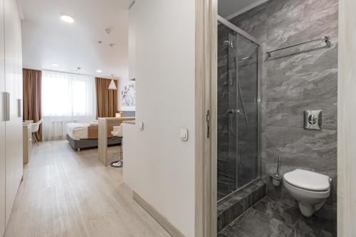 ein Bad mit einer Dusche und einem WC sowie ein Schlafzimmer in der Unterkunft Yes apartments in Astana