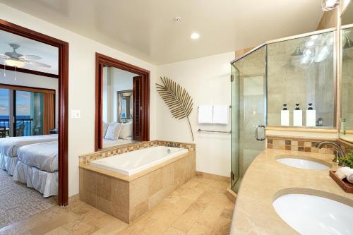 La salle de bains est pourvue d'une baignoire, d'un lit et d'une douche. dans l'établissement Waipouli Beach Resort G-404, à Kapaa