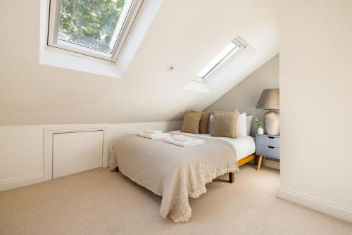 a bedroom with a bed and a window at The Stratford Villas in London